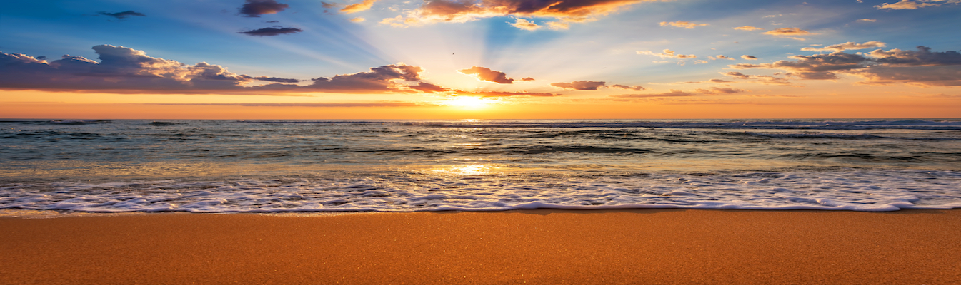 The sun shines over calming blue skies overlooking the Los Angeles beach shore.